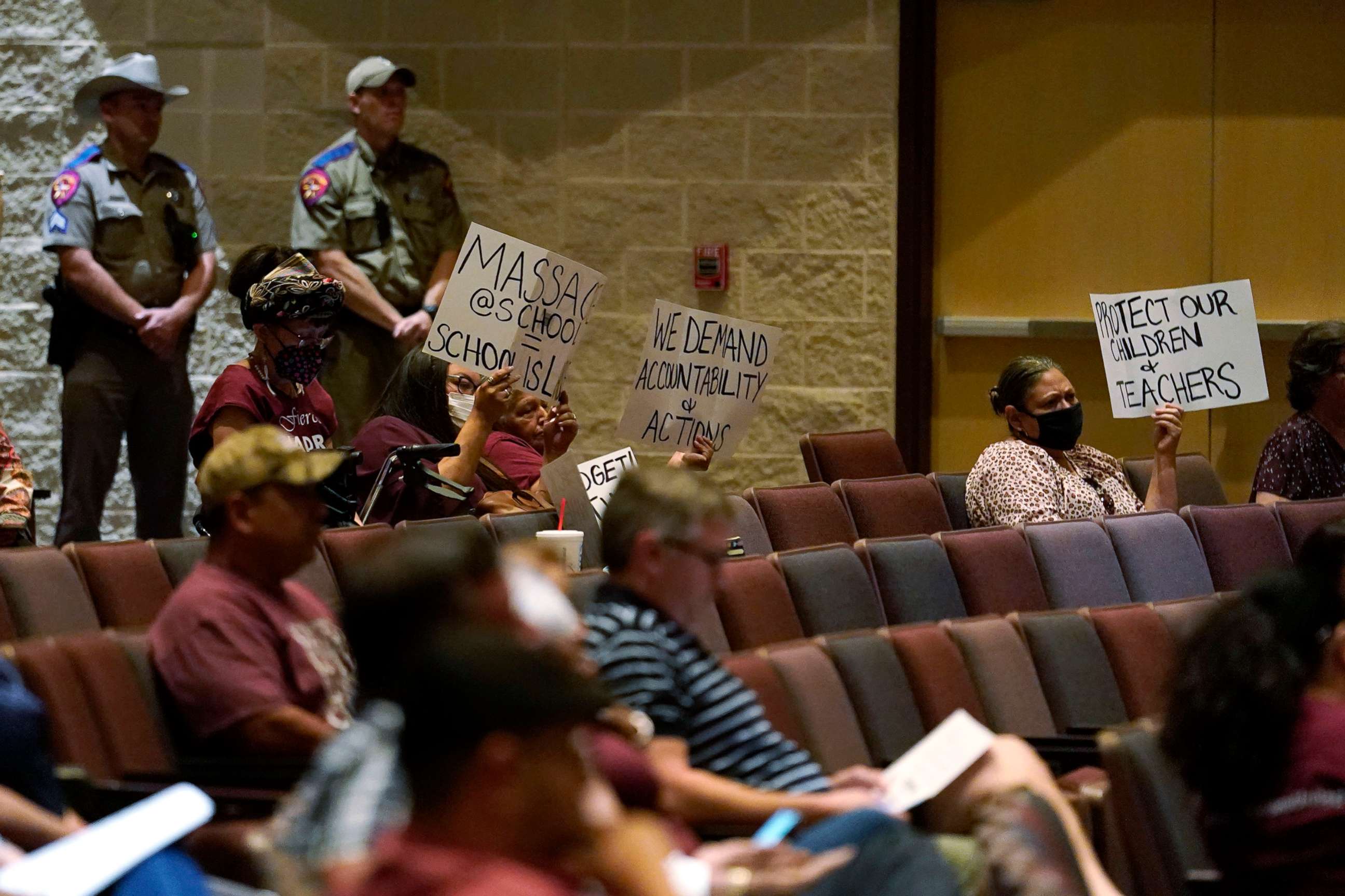 PHOTO: Parents and family hold protest signs during a special meeting of the Board of Trustees of Uvalde Consolidated Independent School District where parents addressed last month's shooting at Robb Elementary School, on July 18, 2022, in Uvalde, Texas.