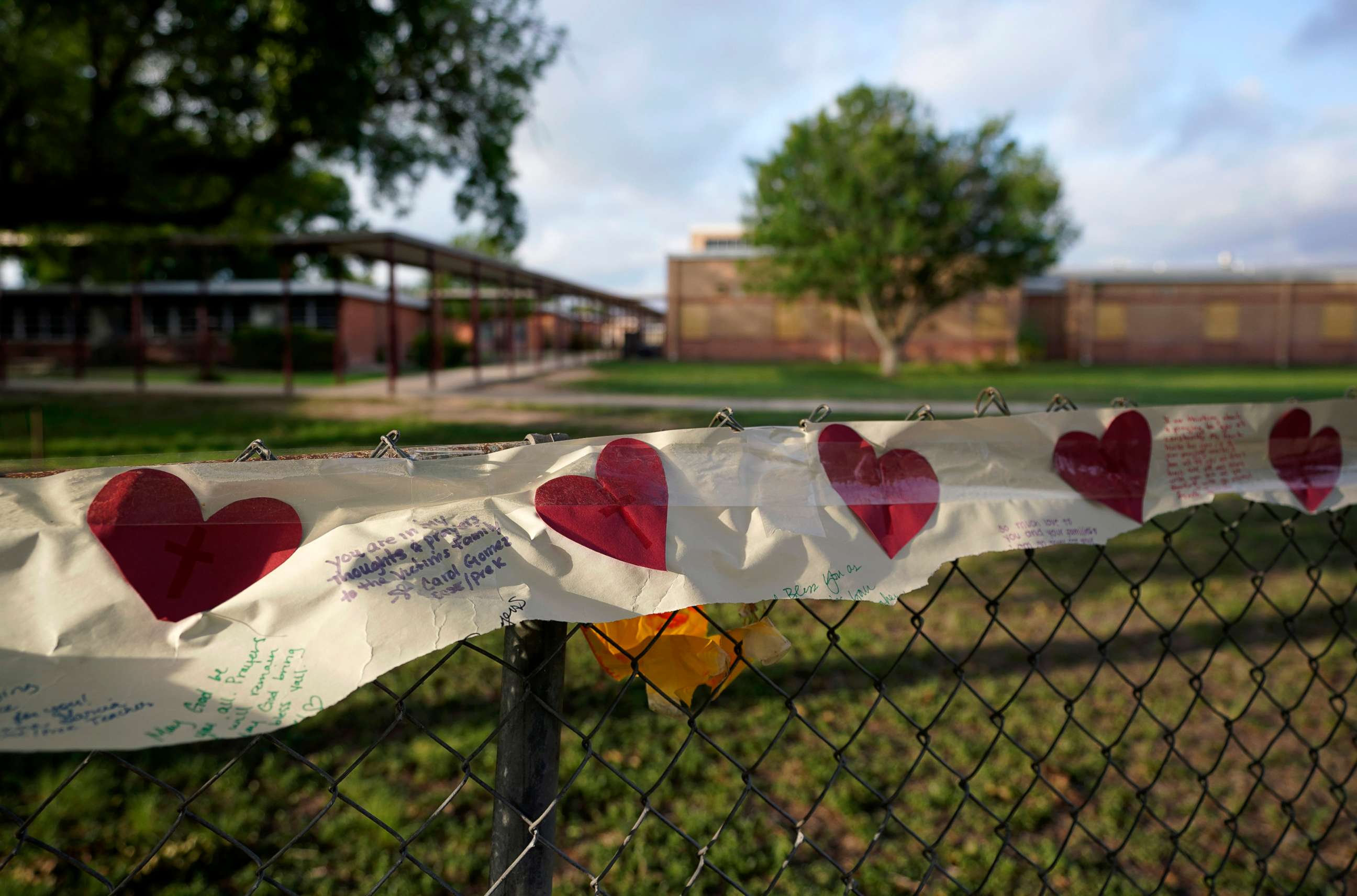 PHOTO: Hearts decorate a banner in front of the boarded up Robb Elementary School building where a memorial has been created to honor the victims killed in the recent school shooting, June 3, 2022, in Uvalde, Texas.