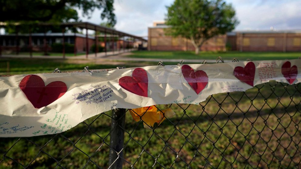PHOTO: Hearts decorate a banner in front of the boarded up Robb Elementary School building where a memorial has been created to honor the victims killed in the recent school shooting, June 3, 2022, in Uvalde, Texas.