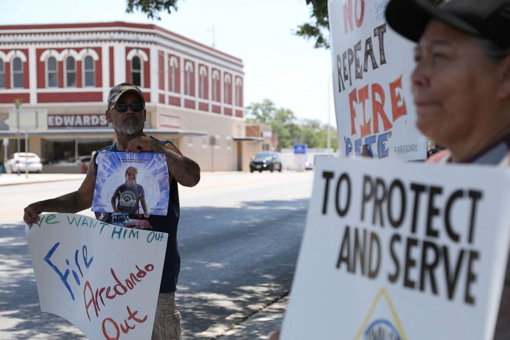 PHOTO: Jessie Rodriguez protests for the removal of Uvalde schools Police Chief Pete Arredondo, next to the memorial for the victims of the shooting, at Uvalde Town Square, Texas, U.S., June 11, 2022. 