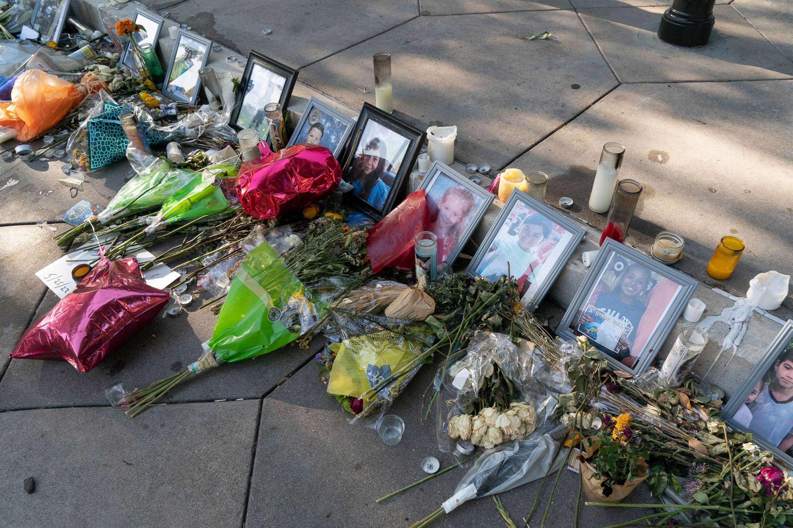 PHOTO: Images of many victims in the Uvalde, Texas mass murder at Robb Elementary lie among burned candles and fading flowers at the steps to the Capitol grounds in Austin, Texsa, May 30, 2022.