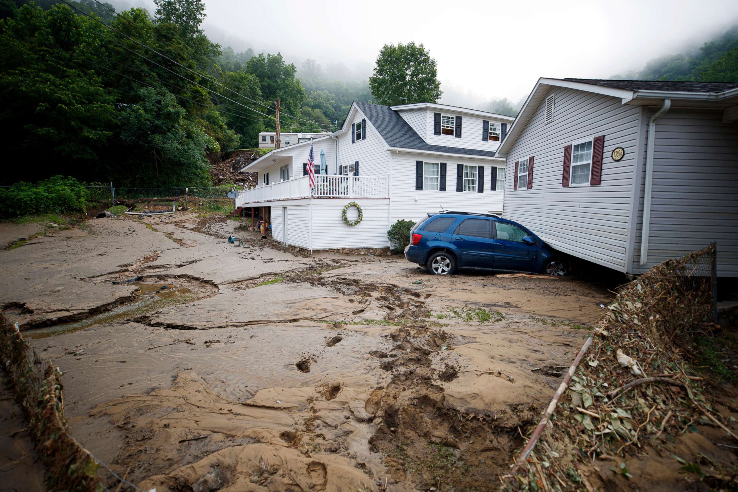 PHOTO: A house moved off of its foundation following a flash flood rests on top of a vehicle, July 14, 2022 in Whitewood, Va.
