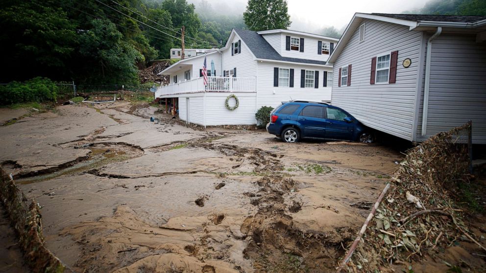 PHOTO: A house moved off of its foundation following a flash flood rests on top of a vehicle, July 14, 2022 in Whitewood, Va.