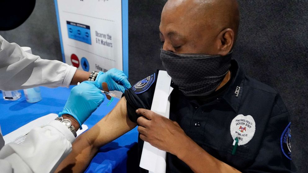 PHOTO: A Jackson State University police officer watches as a nurse gives him a dose of the Pfizer COVID-19 vaccine at an open vaccination site at Jackson State University in Jackson, Miss., Aug. 3, 2021.