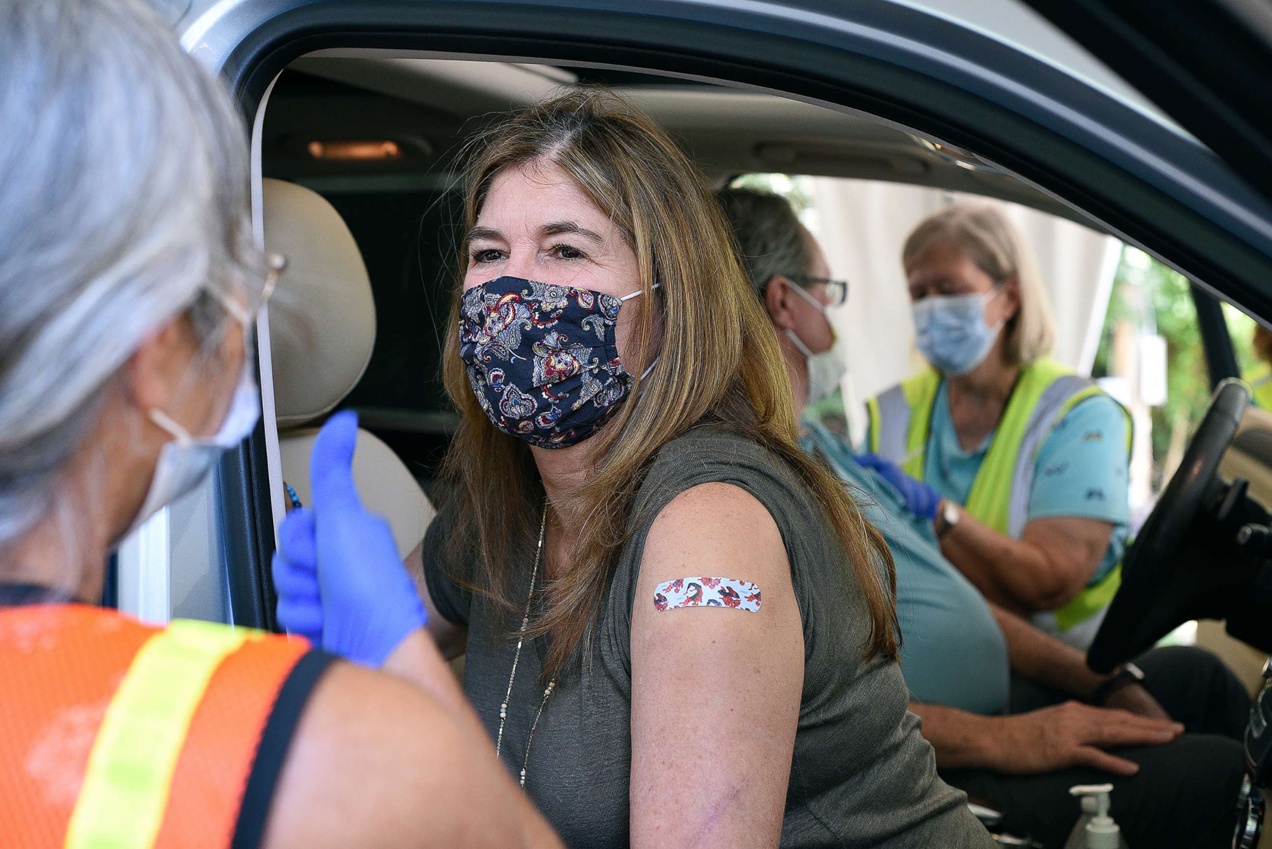 PHOTO: Nurse Abbe Hildebrandt, left, gives a thumbs up to Holli Harris as nurse Sandra Young, right, administers a dose of COVID-19 vaccine to her husband Allen Harris at the Tennessee Riverpark, Sept. 28, 2021, in Chattanooga, Tenn. 