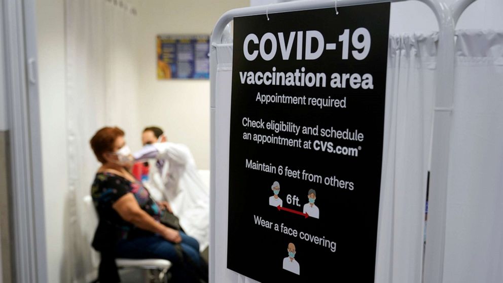 PHOTO: A patient receives a shot of the Moderna COVID-19 vaccine next to a guidelines sign at a CVS Pharmacy branch in Los Angeles, March 1, 2021.