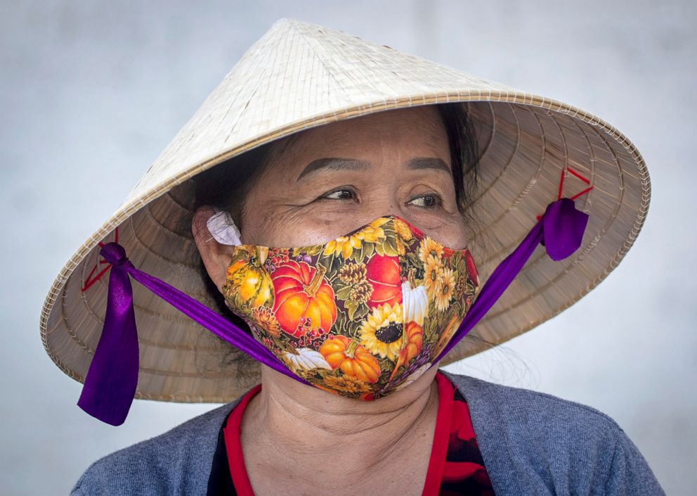 PHOTO:Tu Nguyen wears a traditional Vietnamese hat paired with a protective COVID-19 mask while shopping at the Asian Garden Mall in the Little Saigon area of Westminster, Calif., Aug. 5, 2020.