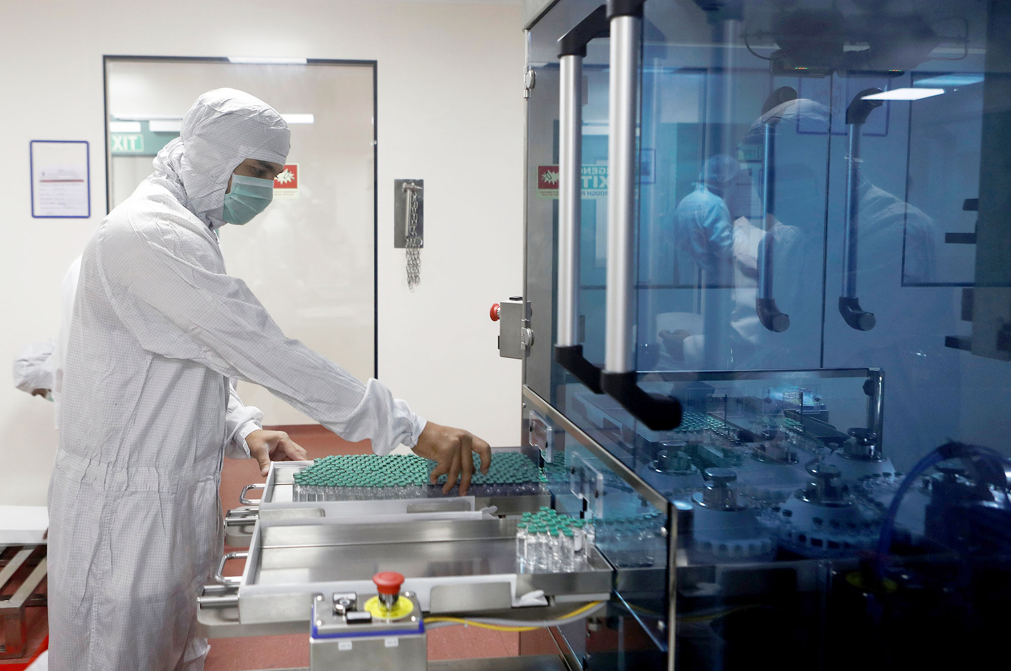 PHOTO: An employee in personal protective equipment removes vials of AstraZeneca's COVISHIELD, coronavirus vaccine from a visual inspection machine inside a lab at Serum Institute of India, in Pune, India, Nov. 30, 2020.