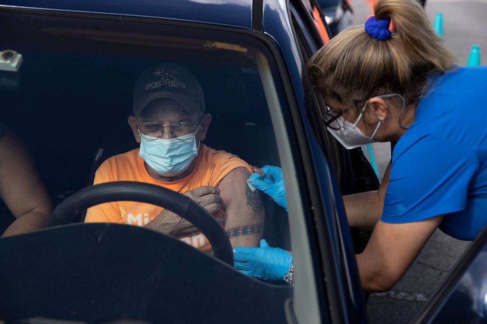 PHOTO: A healthcare worker administers a Pfizer-BioNTech COVID-19 vaccine to a person at a drive-thru site in Tropical Park on Dec. 16, 2021, in Miami.