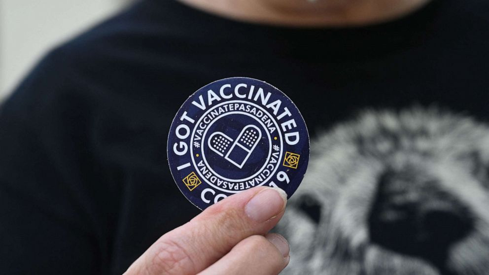 PHOTO: A woman holds up a sticker after getting her third "booster" dose of Covid-19 vaccine at a clinic hosted by The Tournament of Roses in partnership with the Pasadena Public Health Department, Aug. 19, 2021, in Pasadena, California.