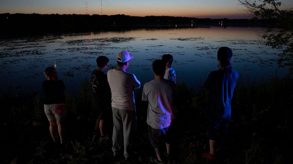 PHOTO: Friends and family gathered at Vadnais Lake after news of a dead child being pulled out of the lake broke, July 1, 2022 in Vadnais Heights, Minn.