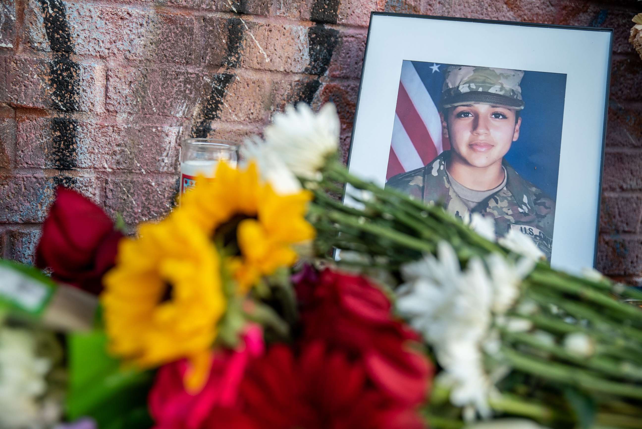 PHOTO: Flowers are laid in front of a photos of murdered Army Spec. Vanessa Guillen, July 12, 2020, in Austin, Texas.