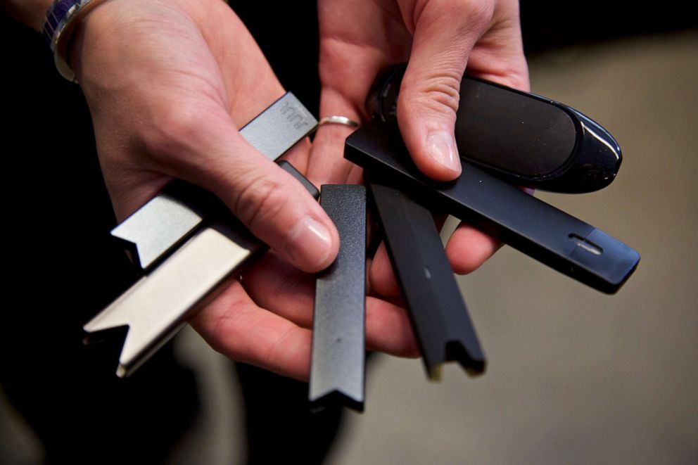 PHOTO: In this April 16, 2019, file photo, a researcher holds vape pens in a lab at Portland State University in in Portland, Ore. 