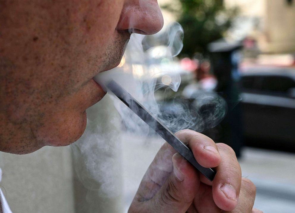 PHOTO: This photo illustration shows a man exhaling smoke from an electronic cigarette in Washington, DC on September 12, 2019.