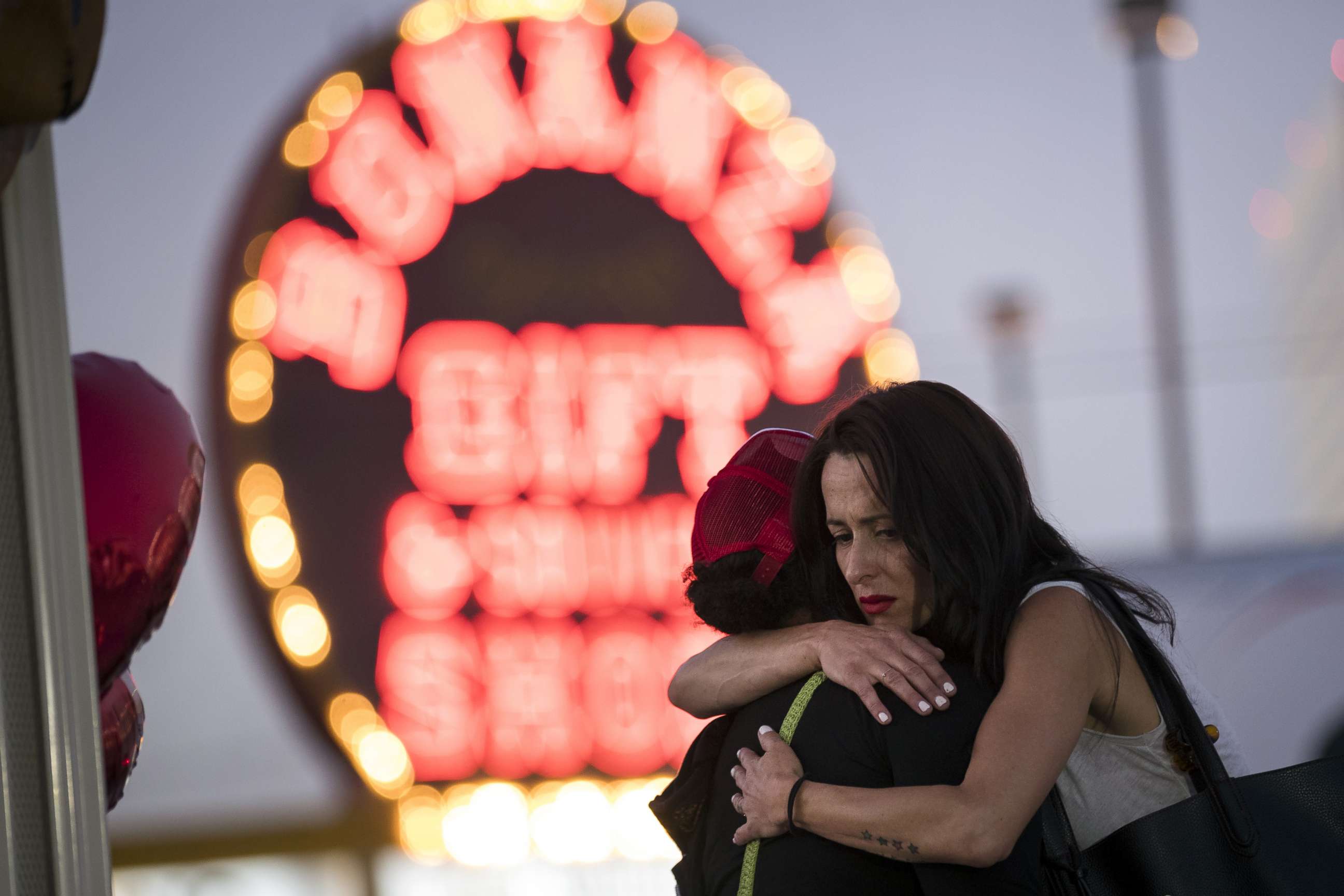 PHOTO: Las Vegas resident Elisabeth Apcar, right, hugs a woman at a makeshift memorial on the Last Vegas Strip, Oct. 4, 2017, three days after a mass shooting.