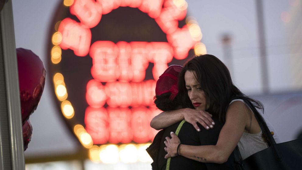 PHOTO: Las Vegas resident Elisabeth Apcar, right, hugs a woman at a makeshift memorial on the Last Vegas Strip, Oct. 4, 2017, three days after a mass shooting.