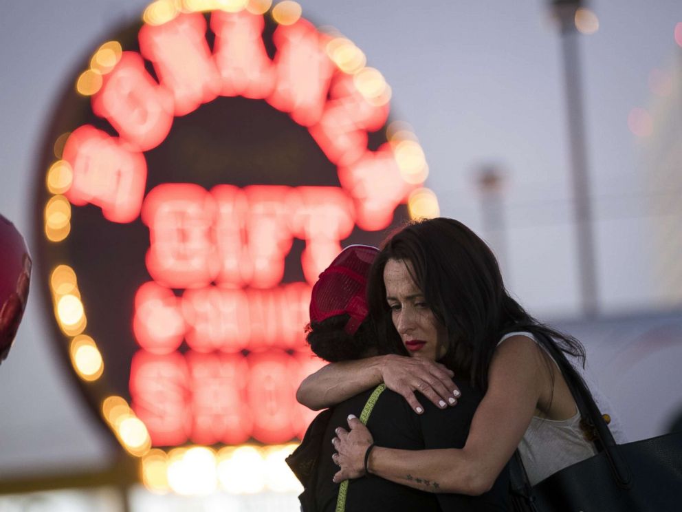 PHOTO: Las Vegas resident Elisabeth Apcar, right, hugs a woman at a makeshift memorial on the Last Vegas Strip, Oct. 4, 2017, three days after a mass shooting.