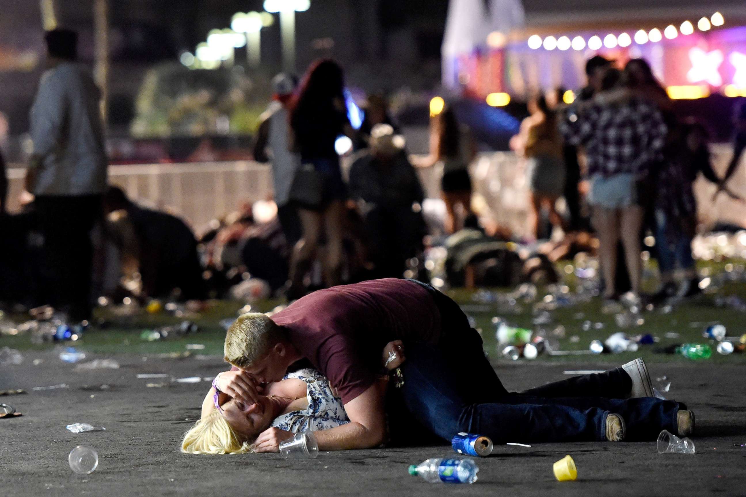PHOTO: A man lays on top of a woman as others flee the Route 91 Harvest country music festival grounds after an active shooter was reported on Oct. 1, 2017 in Las Vegas. The woman later was seen getting up with help. 