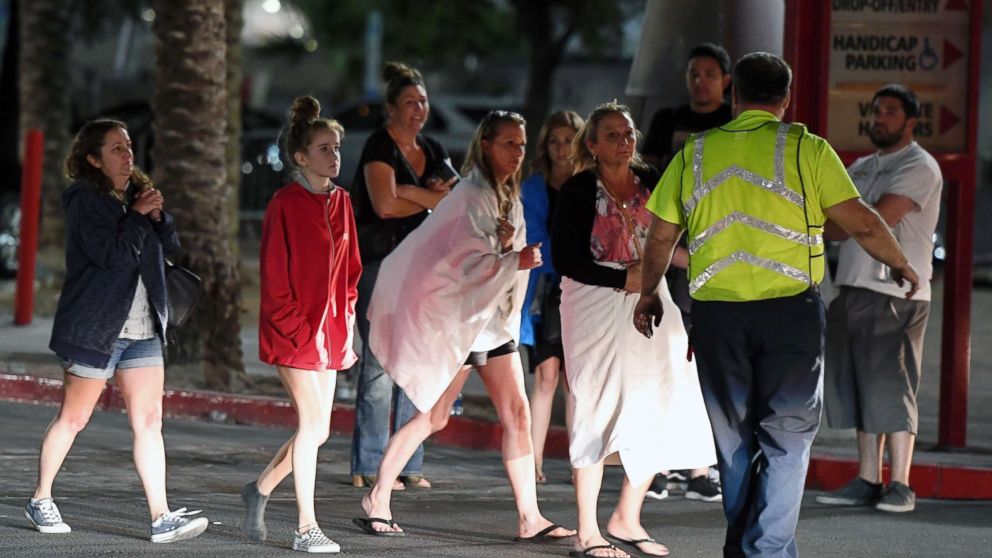 People are directed to rides outside the Thomas & Mack Center after a mass shooting at a country music festival, Oct. 2, 2017, in Las Vegas.