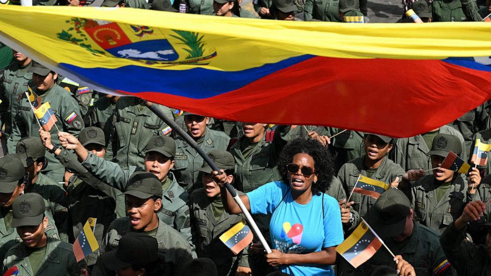 PHOTO: A woman waves a Venezuelan flag among members of the National Bolivarian Armed Forces during a rally in support of ousted Venezuela's President Nicolas Maduro and his wife Cilia Flores in Caracas, January 6, 2026.
