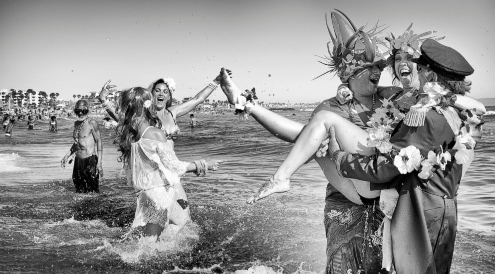 PHOTO: Neptune Parade - King and Queen Neptune frolic in the Pacific Ocean waters, celebrating the start of summer with the yearly Neptune Parade.