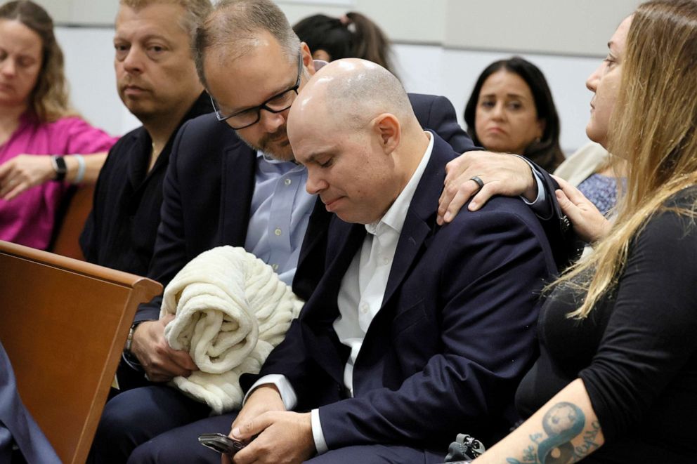 PHOTO: Ryan Petty comforts Ilan Alhadeff as they await the verdict in the trial of Marjory Stoneman Douglas High School shooter Nikolas Cruz at the Broward County Courthouse in Fort Lauderdale, Fla., Oct. 13, 2022.