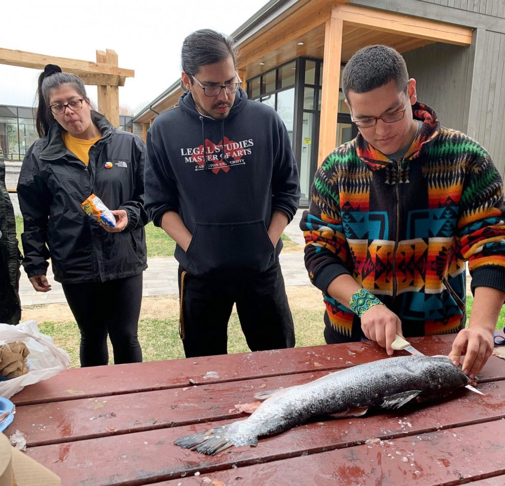 PHOTO: Victor Lopez-Carmen prepares fish to cook with other Indigenous young people.