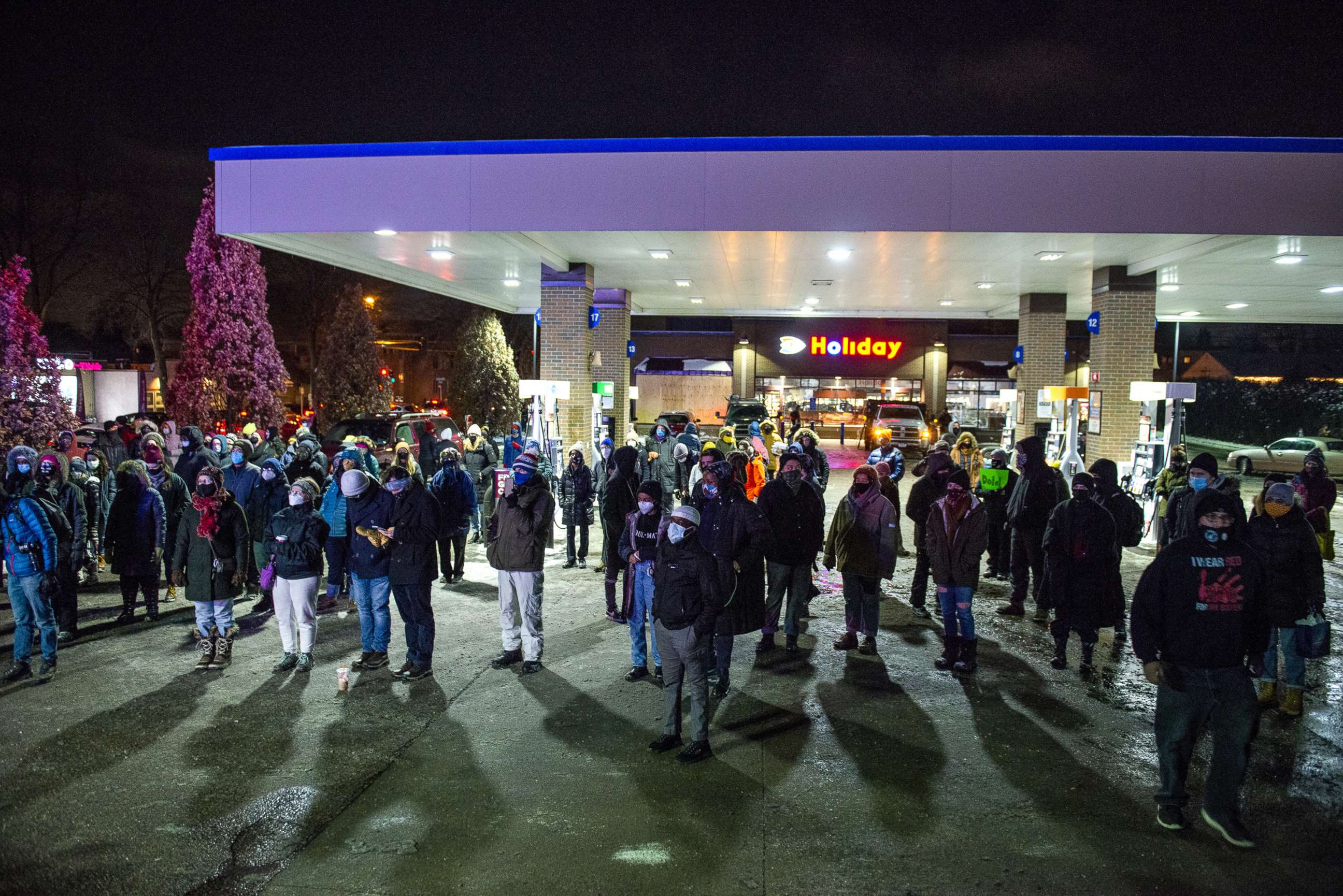 PHOTO: People gather at Holiday gas station where Dolal Idd was shot and killed by Minneapolis Police for a vigil, Dec. 31, 2020, in Minneapolis. 