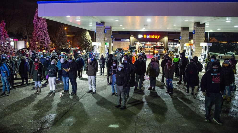 PHOTO: People gather at Holiday gas station where Dolal Idd was shot and killed by Minneapolis Police for a vigil, Dec. 31, 2020, in Minneapolis.