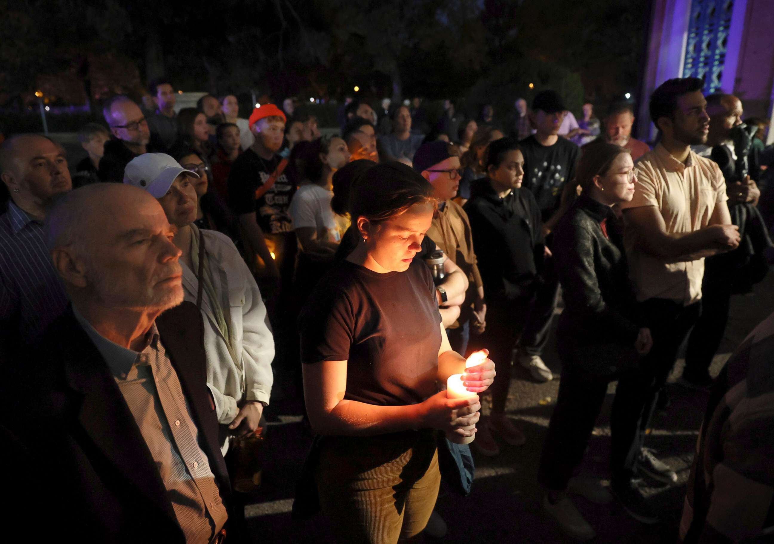 PHOTO: Marie Crane, center, holds a candle during a vigil in Tower Grove Park for the victims of a school shooting at Central Visual & Performing Arts High School in St. Louis, Oct. 24, 2022.