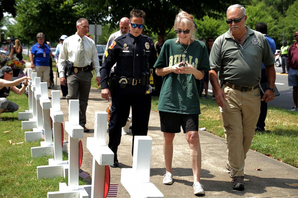 PHOTO: A relative (C) of shooting victim Michelle 'Missy' Langer is escorted by law enforcement officers at a makeshift memorial site at the city Municipal Center, June 2, 2019 in Virginia Beach, Va. 