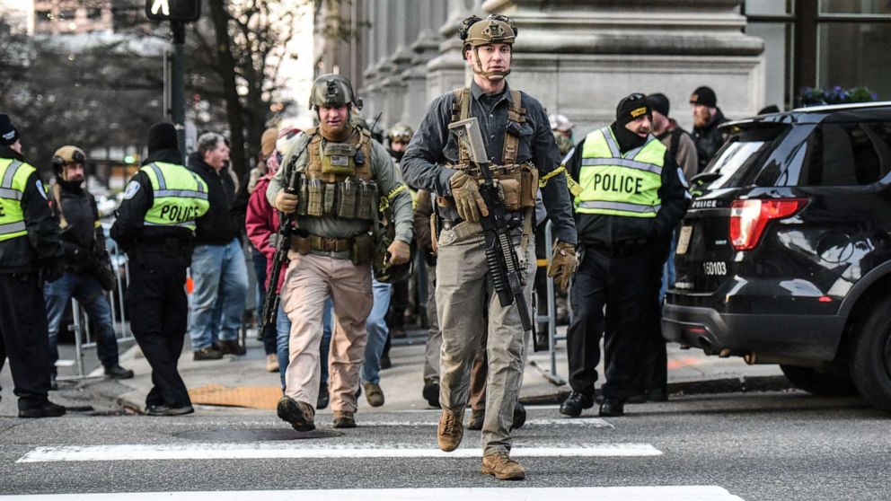 PHOTO: People who are part of an armed militia group walk near the Virginia State Capitol building to advocate for gun rights in Richmond, Va., Jan. 20, 2020. 