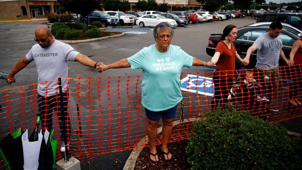PHOTO: Lisa Dunaway, center, of Virginia Beach, Va., holds hands with gatherers during a vigil in response to a shooting at a municipal building in Virginia Beach, Va., June 1, 2019.