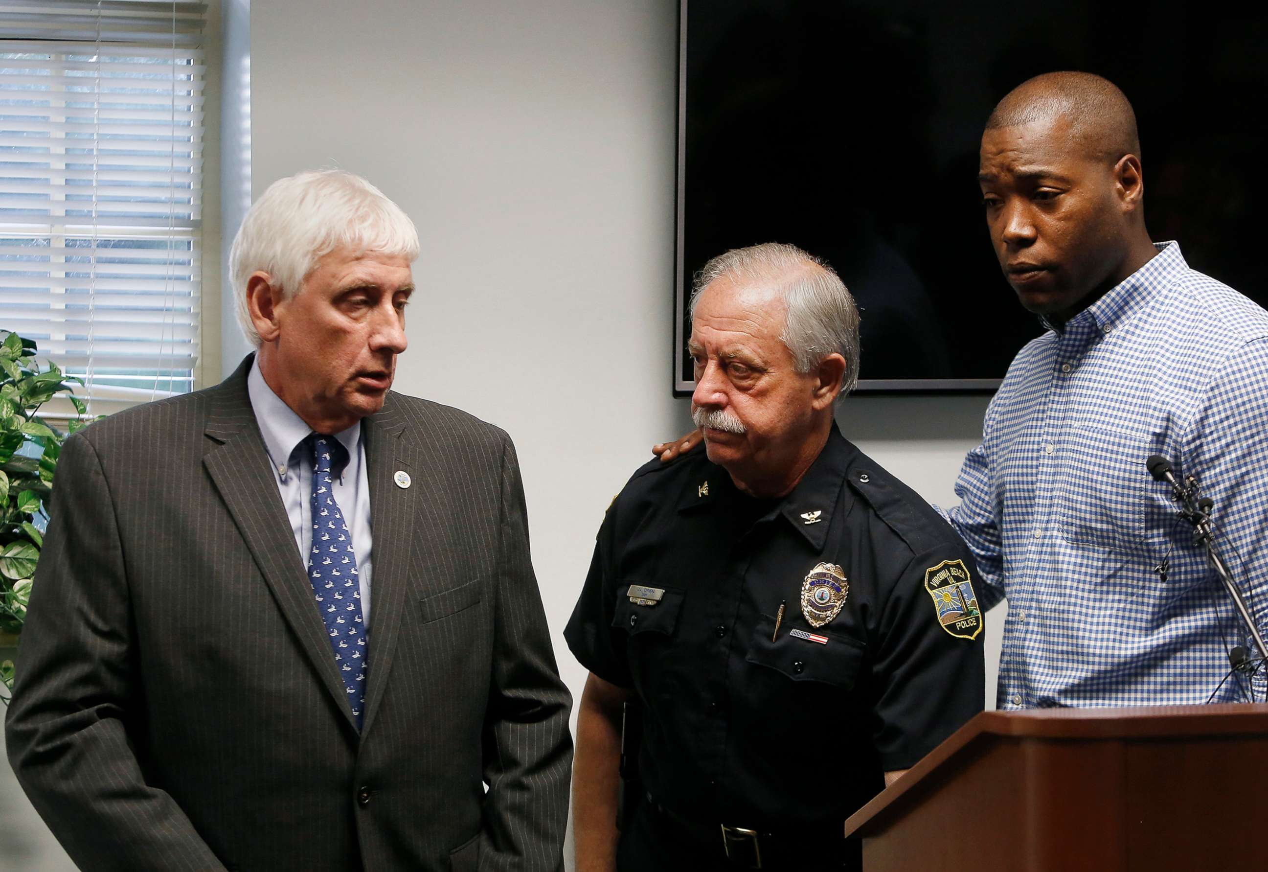 PHOTO: Virginia Beach Mayor Bobby Dyer, left, looks on as City Councilman Aaron Rouse, right, comforts Chief of Police James Cervera following a press conference, May 31, 2019 in Virginia Beach, Va.