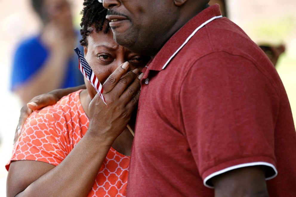 PHOTO: A coworker of LaQuita Brown, a victim of a mass shooting at a municipal building in Virginia Beach, Va., is comforted before carrying a cross bearing Brown's name to a nearby makeshift memorial, June 2, 2019.