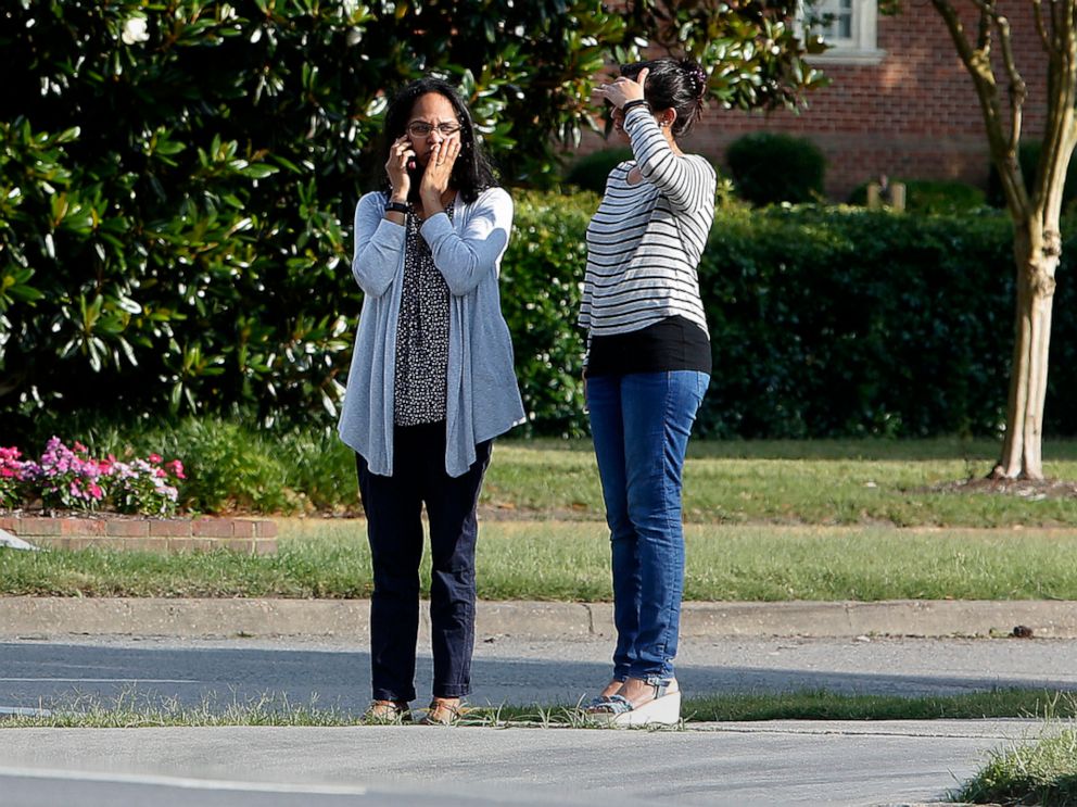 PHOTO: Women wait by an entrance to the Virginia Beach Municipal Center on Princess Anne Road following a shooting in the public works building, May 31, 2019 in Virginia Beach, Va. 