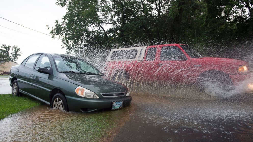 PHOTO: A truck passes a partially submerged abandoned vehicle in Lynchburg, Va. during a thunderstorm, Aug. 2, 2018.