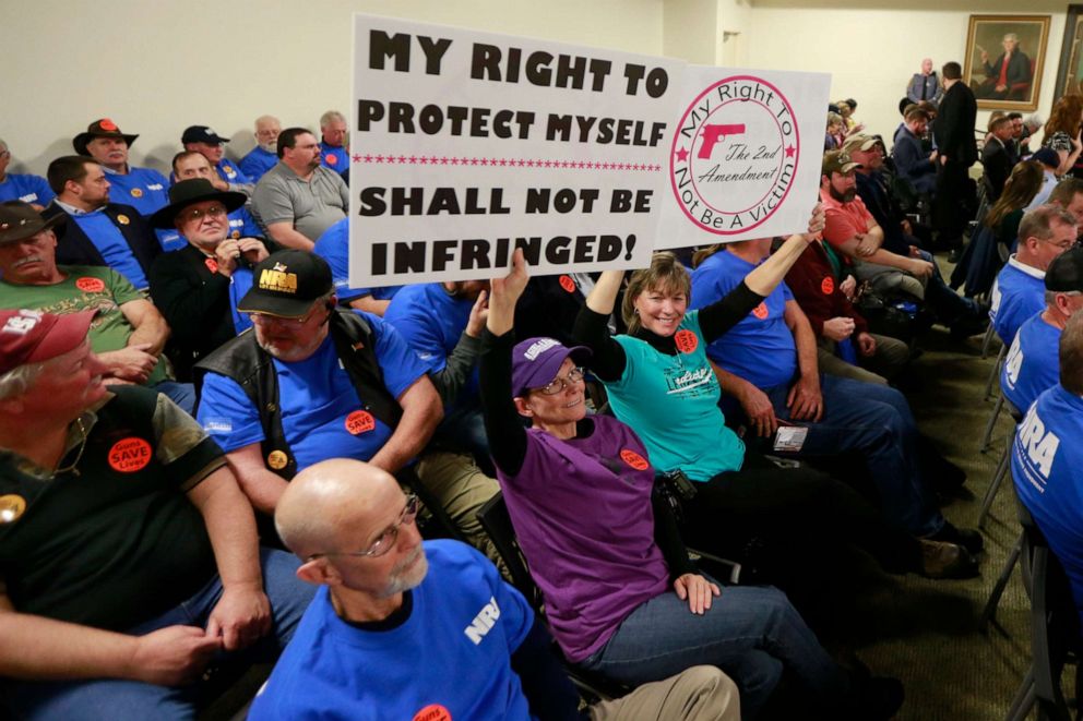 PHOTO: Gun rights protesters hold signs prior to the start of a meeting of the Senate Judiciary committee at the Capitol in Richmond, Va., Jan. 13, 2020.