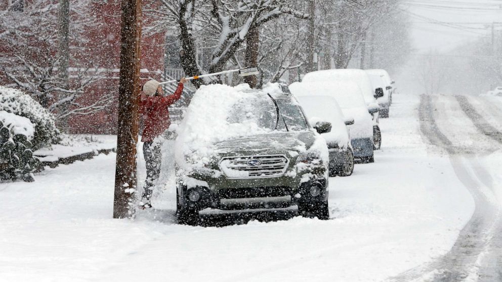 PHOTO: A woman clears snow from a vehicle during a winter storm, Jan. 31, 2021, in Richmond, Va.