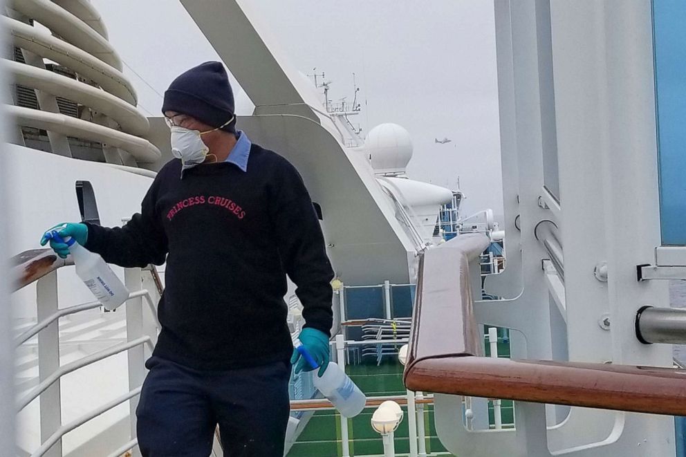 PHOTO: In this photo provided by Michele Smith, a cruise ship worker cleans a railing on the Grand Princess Thursday, March 5, 2020, off the California coast.