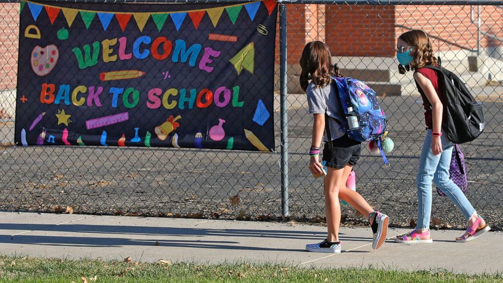 PHOTO: In this Aug. 17, 2020, file photo, Cimmie Hunter, left, and Cadence Ludlow, both 6th graders, arrive at Liberty Elementary School during the first day of class in Murray, Utah.