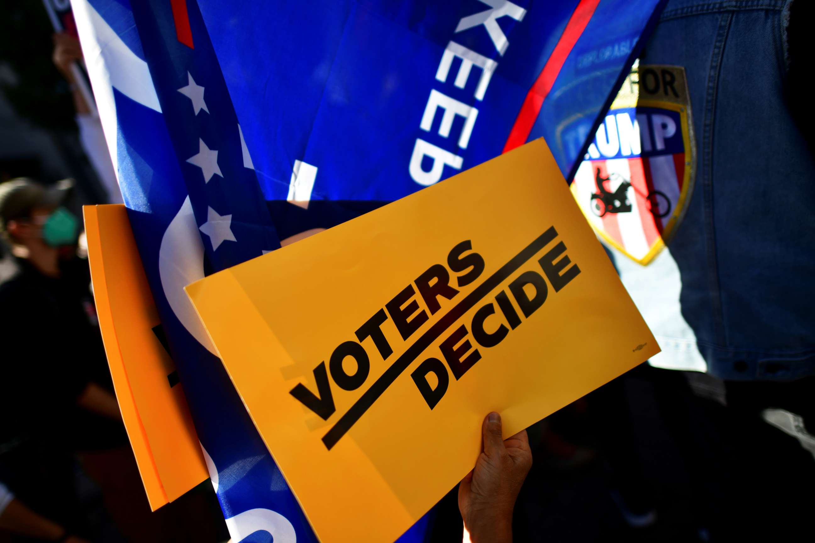 PHOTO: A "Voters Decide" sign is pictured as people demonstrate outside of the Philadelphia Convention Center, where votes are still being counted two days after the 2020 U.S. presidential election, in Philadelphia, Pennsylvania.