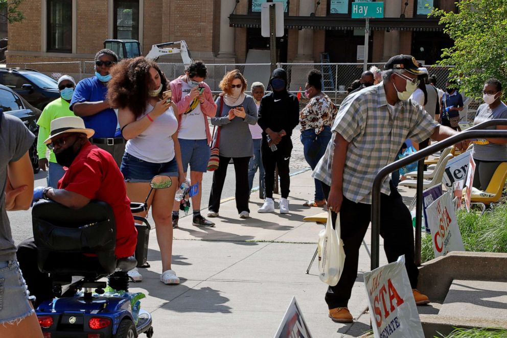 PHOTO: Residents wait in line outside the Wilkinsburg Municipal Building to cast their vote during primary voting, in Pittsburgh, June 2, 2020.