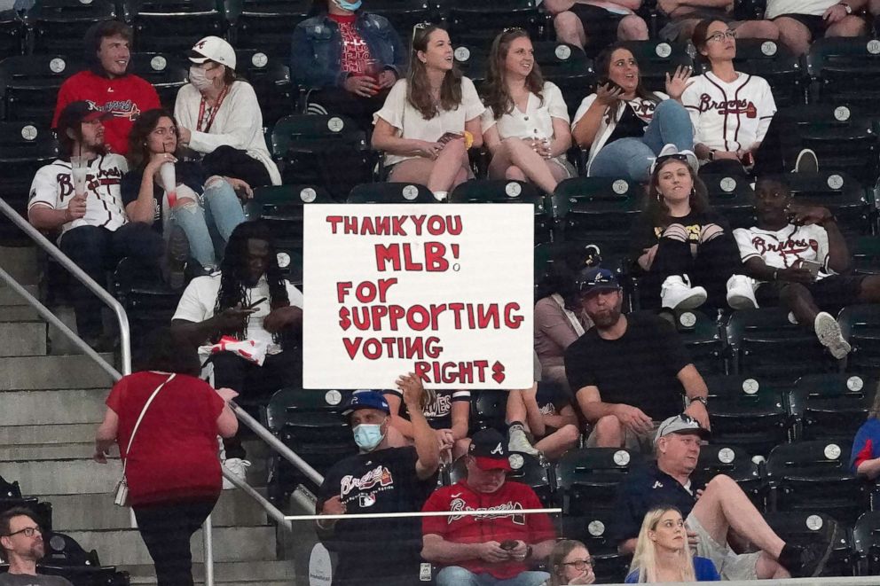 PHOTO: A fan holds a sign supporting Major League Baseball's decision to move the All Star Game from Atlanta because of new election laws during a baseball game between the Chicago Cubs and the Atlanta Braves, April 26, 2021, in Atlanta.
