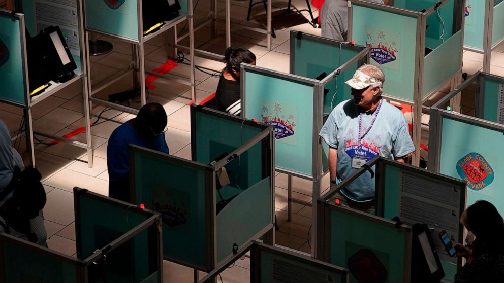PHOTO: An election worker walks through voting booths to help as people vote at a polling place June 14, 2022, in Las Vegas. 
