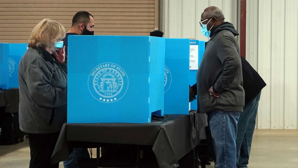 PHOTO: Georgia voters mark their ballots during the first day of early voting in the US Senate runoffs at the Gwinnett County Fairgrounds, Dec. 14, 2020, in Atlanta.