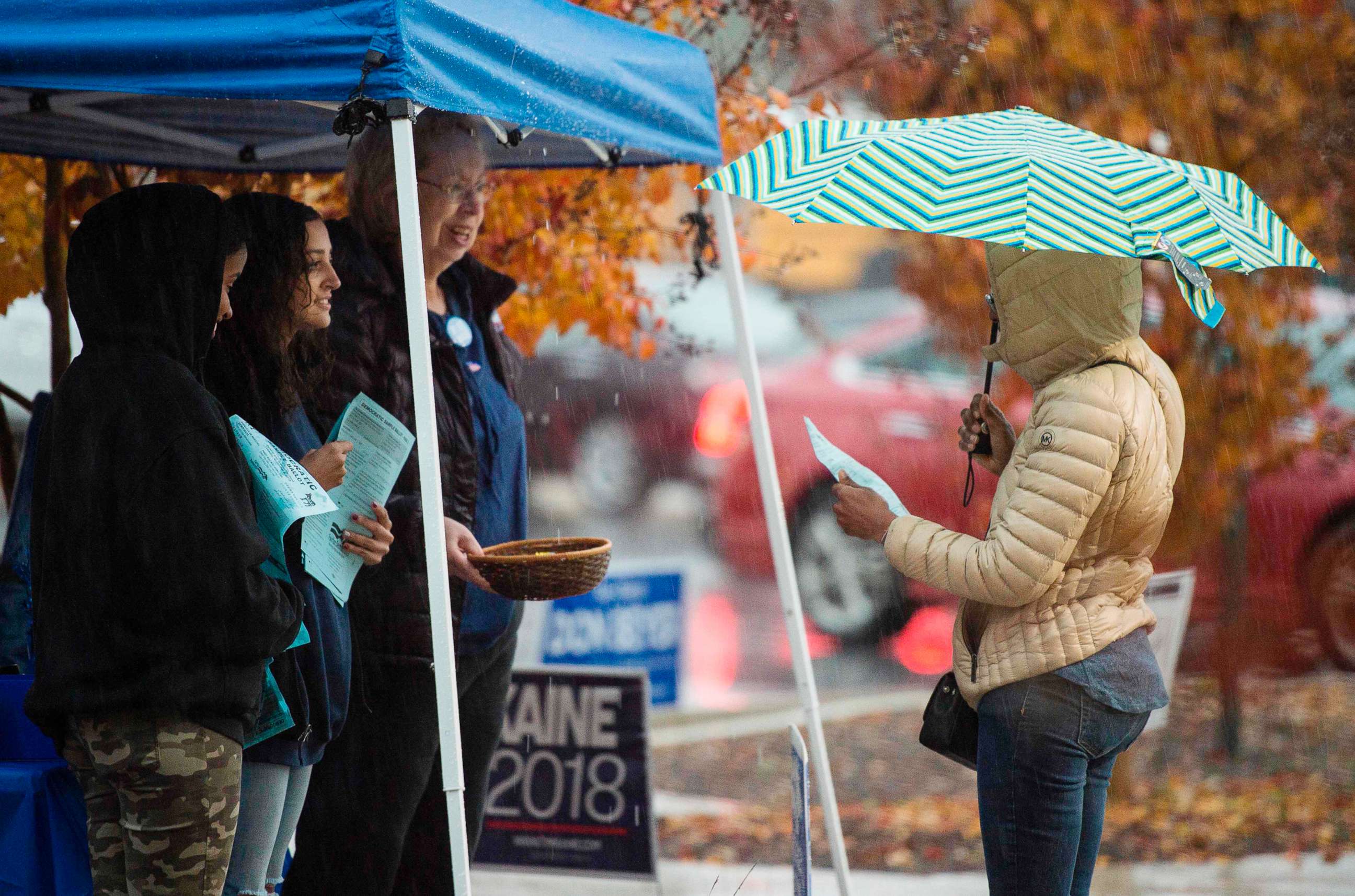 PHOTO: Volunteers with the Democratic party speak to voters outside of a polling station during the mid-term elections at the Fairfax County bus garage in Lorton, Va., Nov. 6, 2018. for the day-long ballot.