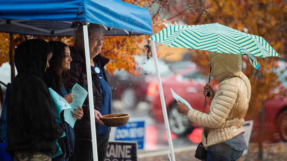 PHOTO: Volunteers with the Democratic party speak to voters outside of a polling station during the mid-term elections at the Fairfax County bus garage in Lorton, Va., Nov. 6, 2018. for the day-long ballot.