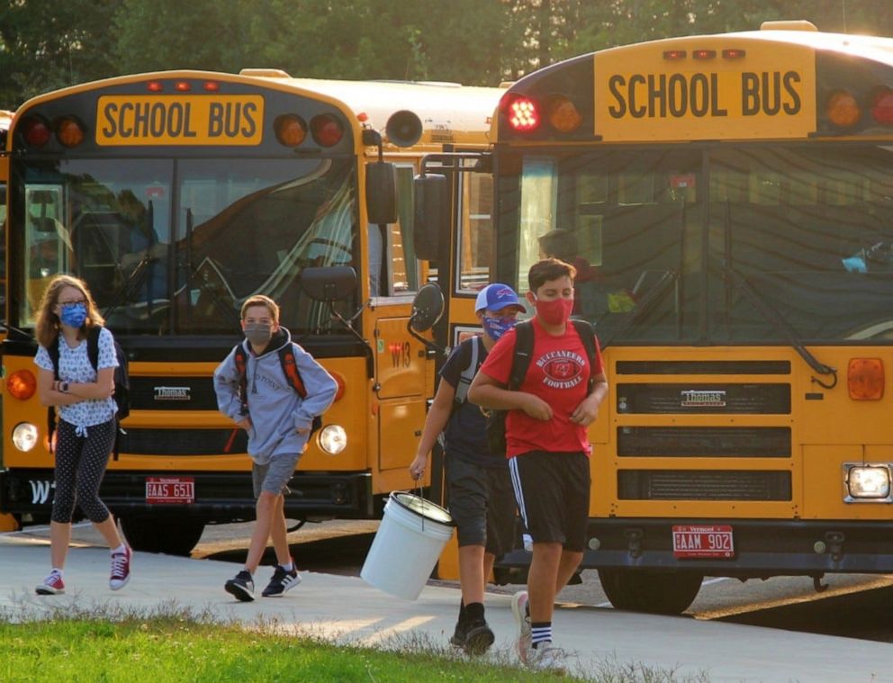 PHOTO: Williston Central School students get off the bus on their way to school in Williston, Vt., Sept. 8, 2020. Bus riders get their temperatures checked as they board the bus.