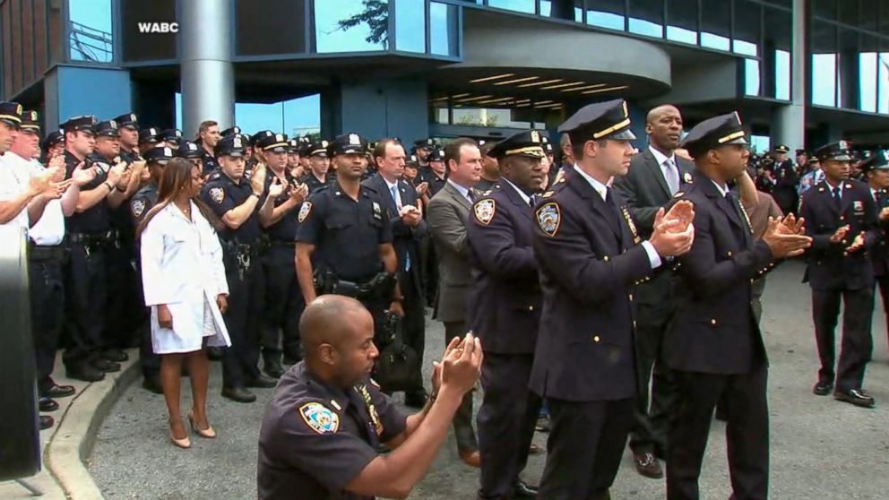 PHOTO: NYPD officers clap as Officer Hart Nguyen leaves the hospital, Aug. 11, 2017.